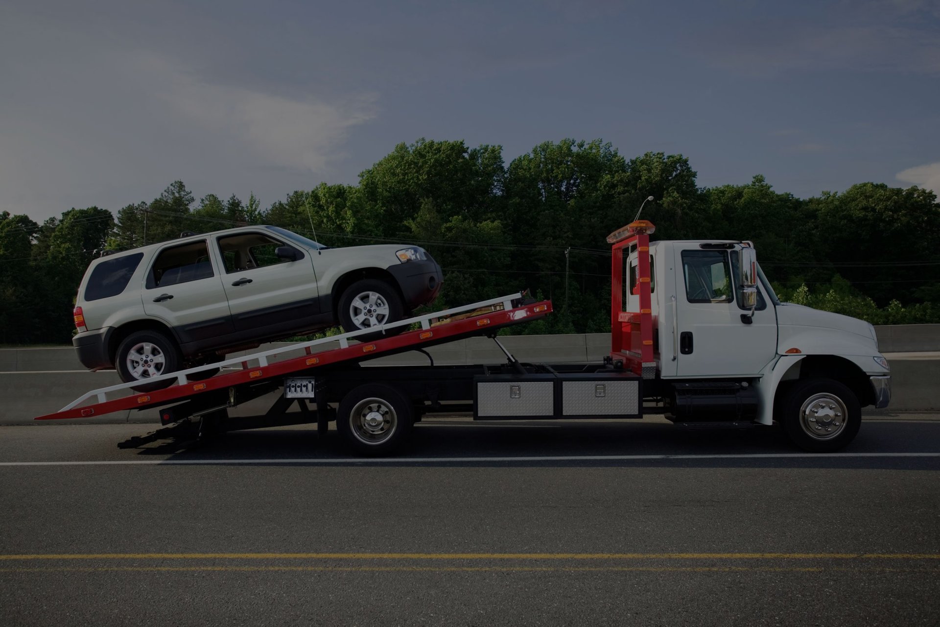 SKW Tow & Transport flatbed truck loading a vehicle in Memphis, TN